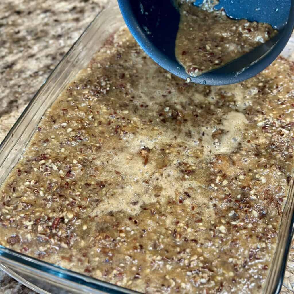 Pouring the topping on fruit cocktail cake.