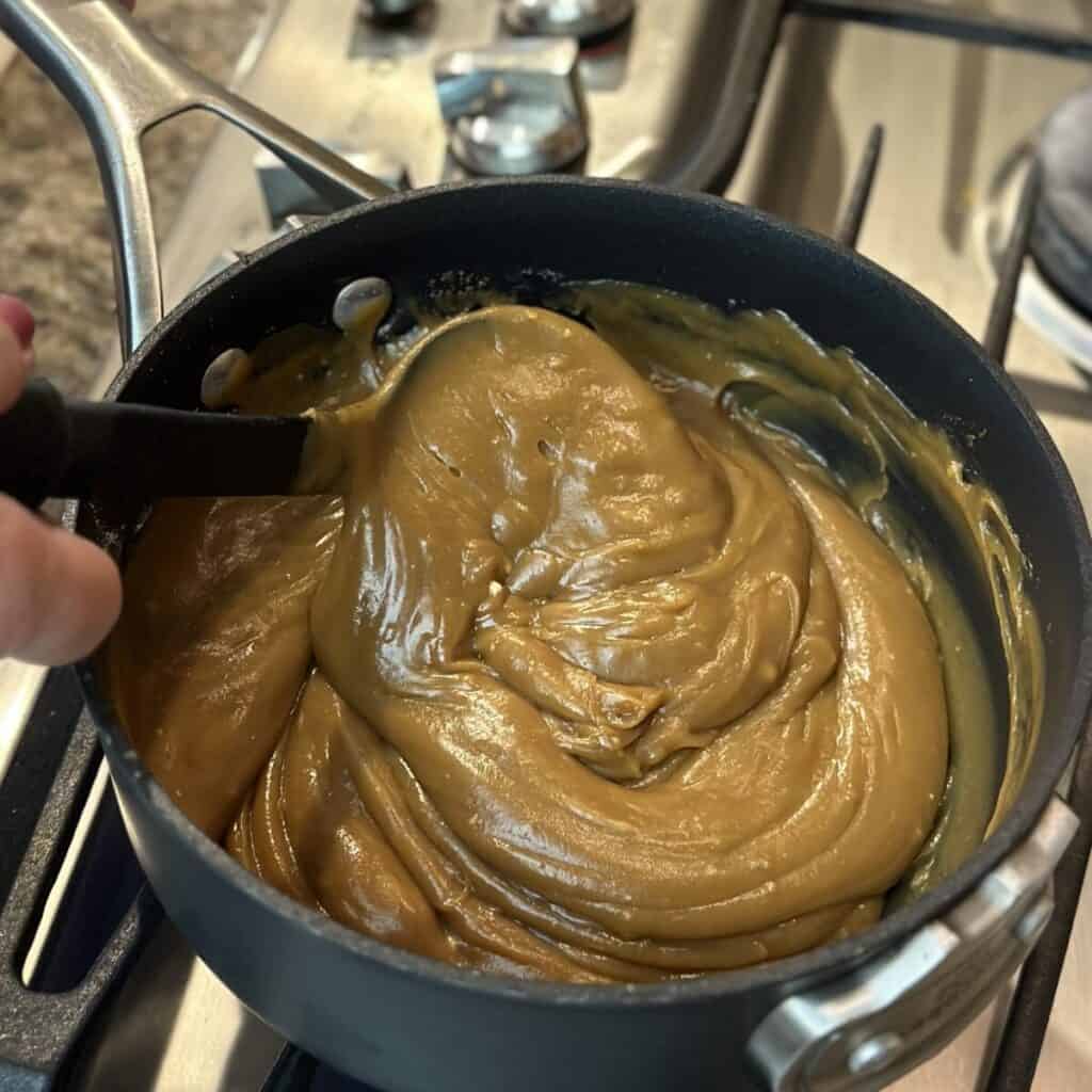 Stirring butterscotch pie filling in a saucepan.