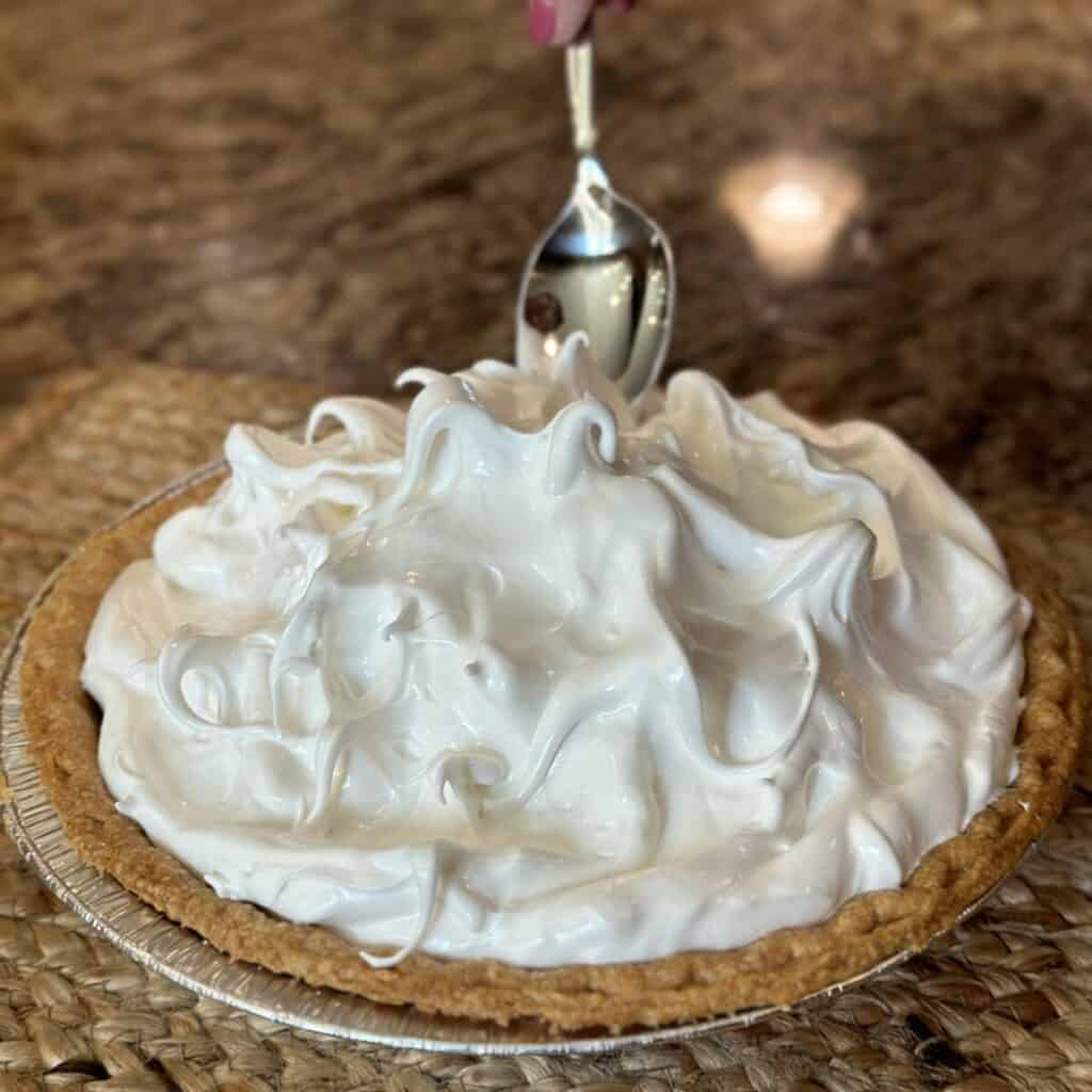 Spreading meringue on a butterscotch pie.