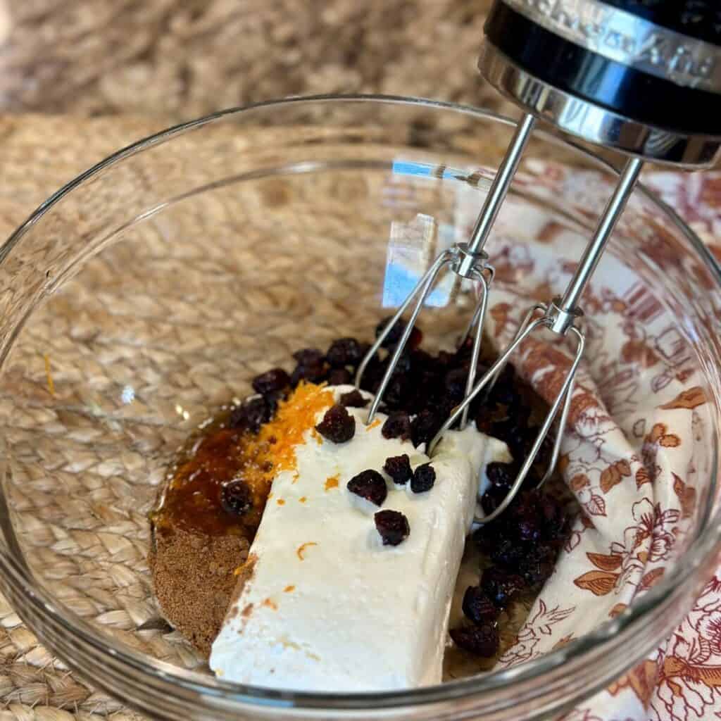 The ingredients in a bowl for cinnamon cream cheese spread.