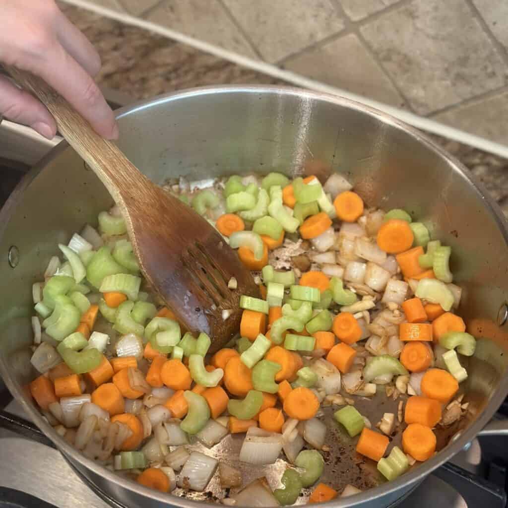 Sautéing vegetables in a pan.