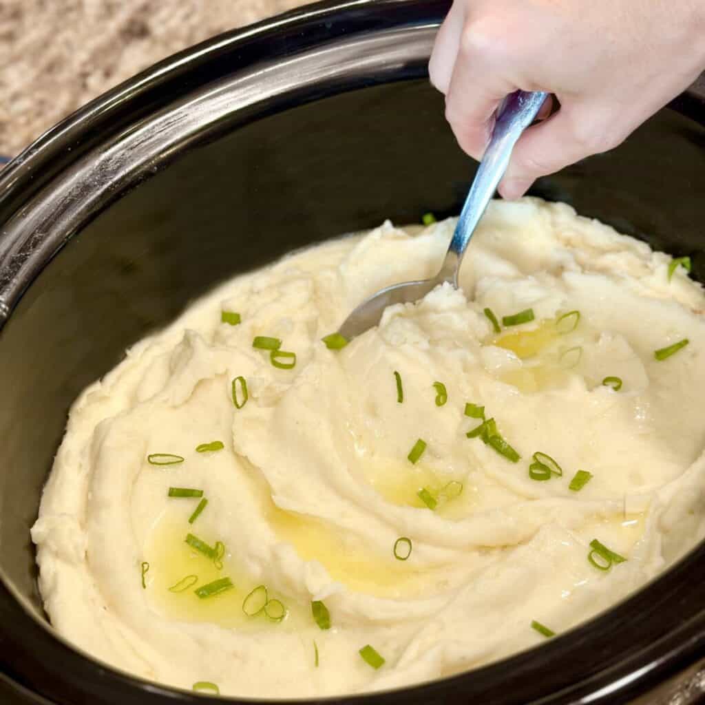 A crockpot full of mashed potatoes. 