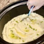 A crockpot full of mashed potatoes.