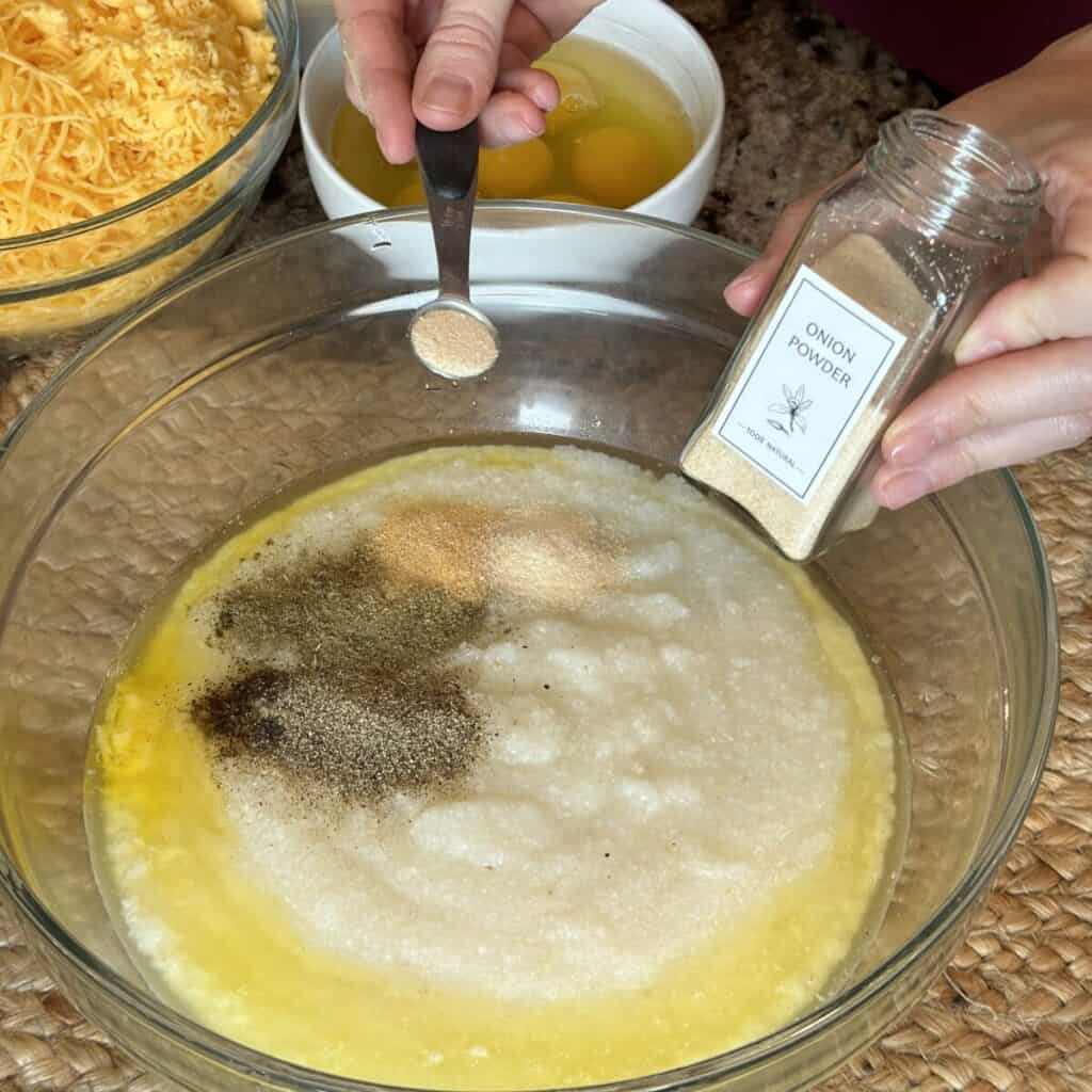 Mixing cooked grits with butter and seasonings.