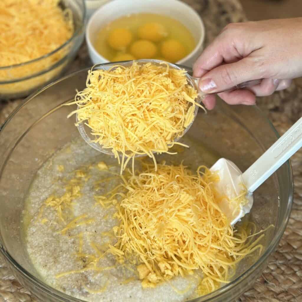 Adding cheese to grits.