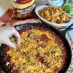 Adding green onions to the top of cornbread chili pie.