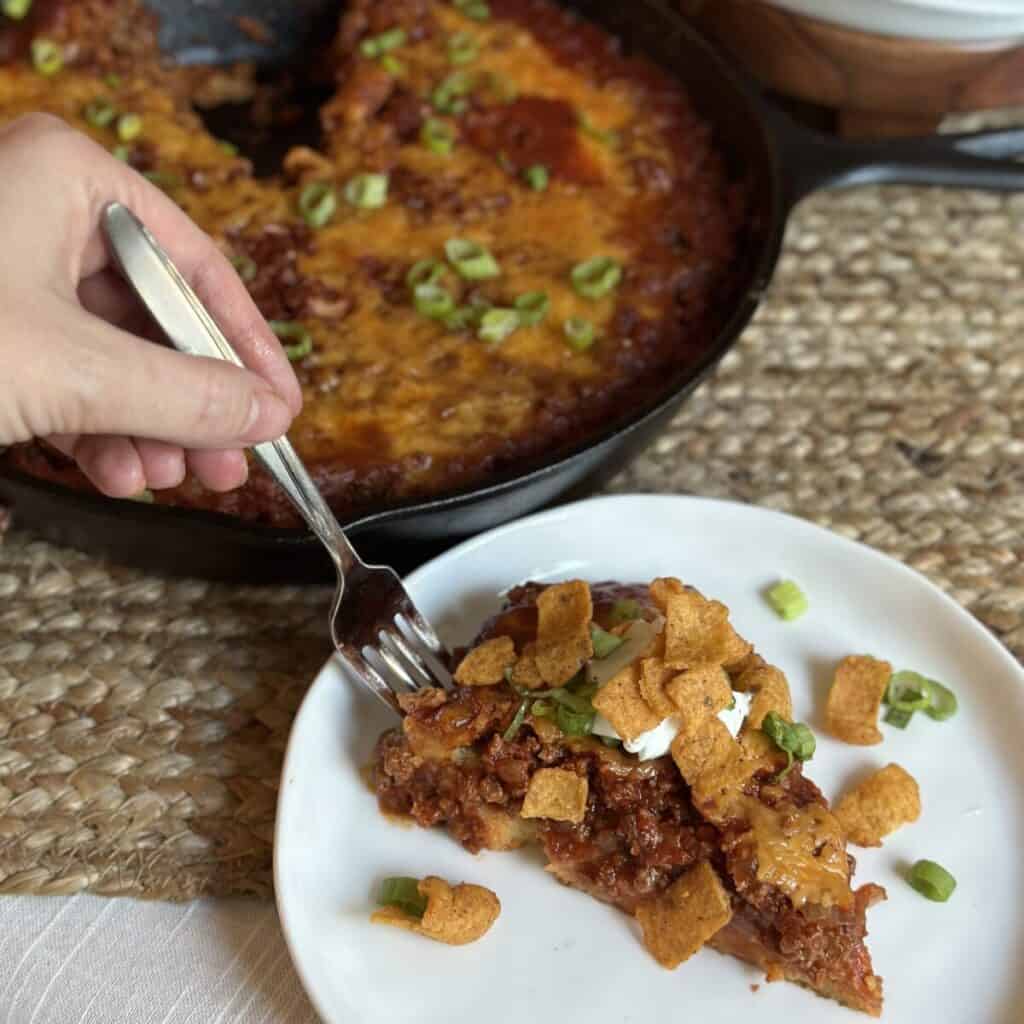 A slice of cornbread chili pie on a saucer.