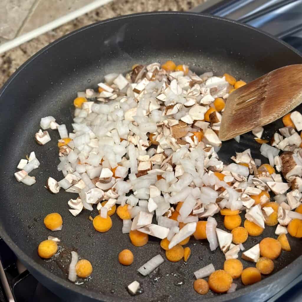 Sautéing vegetables in a skillet.