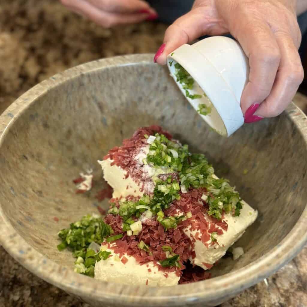 Mixing together the ingredients for a chipped beef cheeseball.