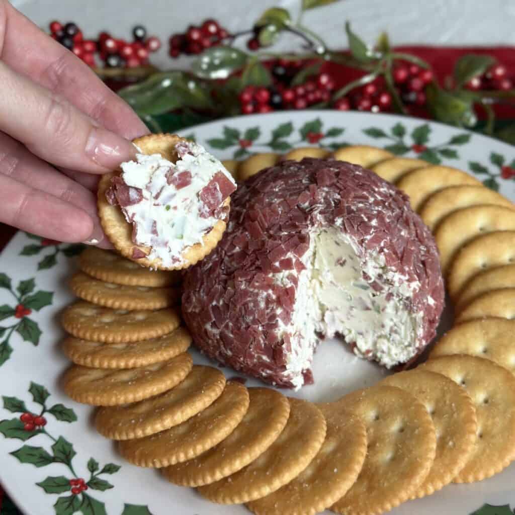 A cheeseball on a plate with crackers.