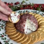 A cheeseball on a plate with crackers.