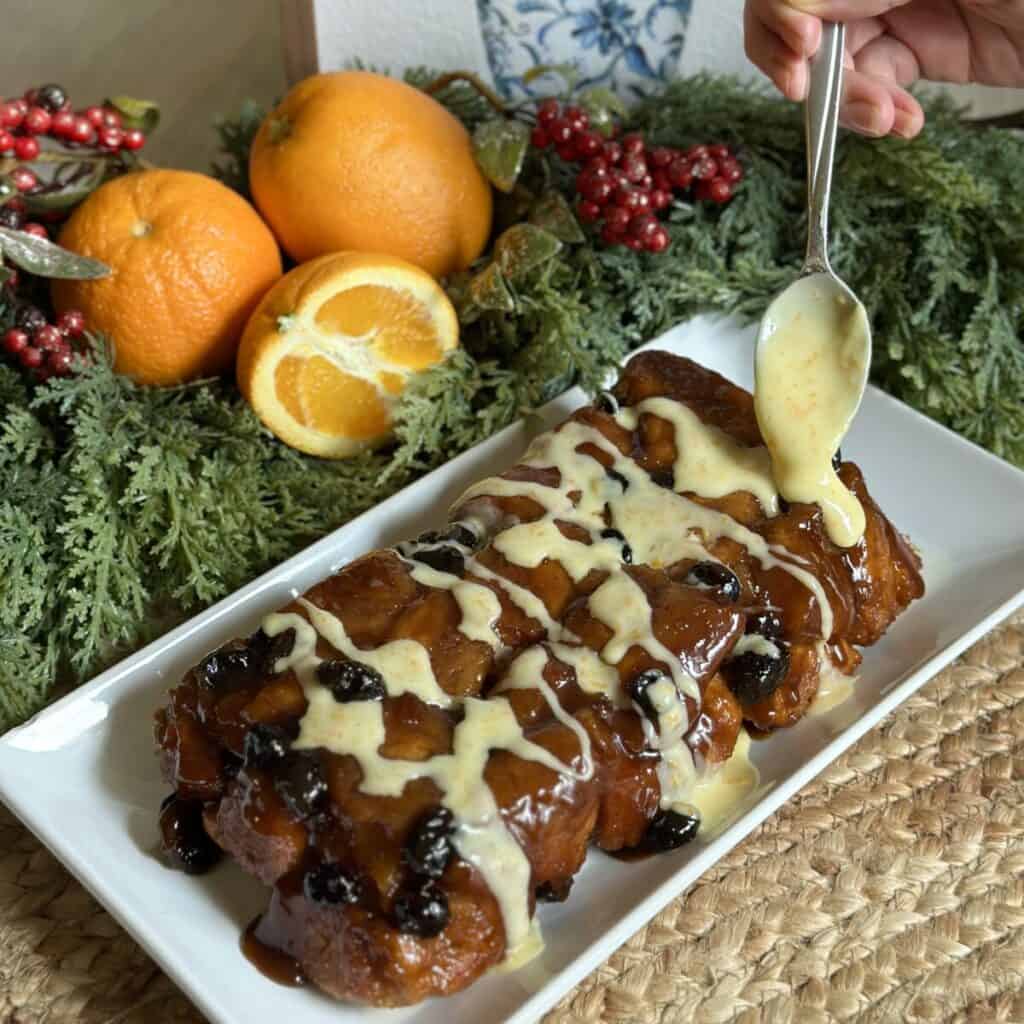 A cranberry orange monkey bread with orange glaze.