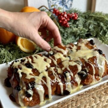 A cranberry orange monkey bread with orange glaze.