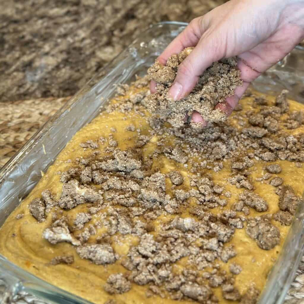 Adding streusel to the top of coffee cake.