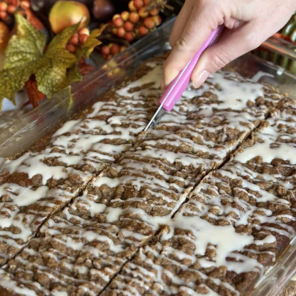 Slicing pumpkin coffee cake.