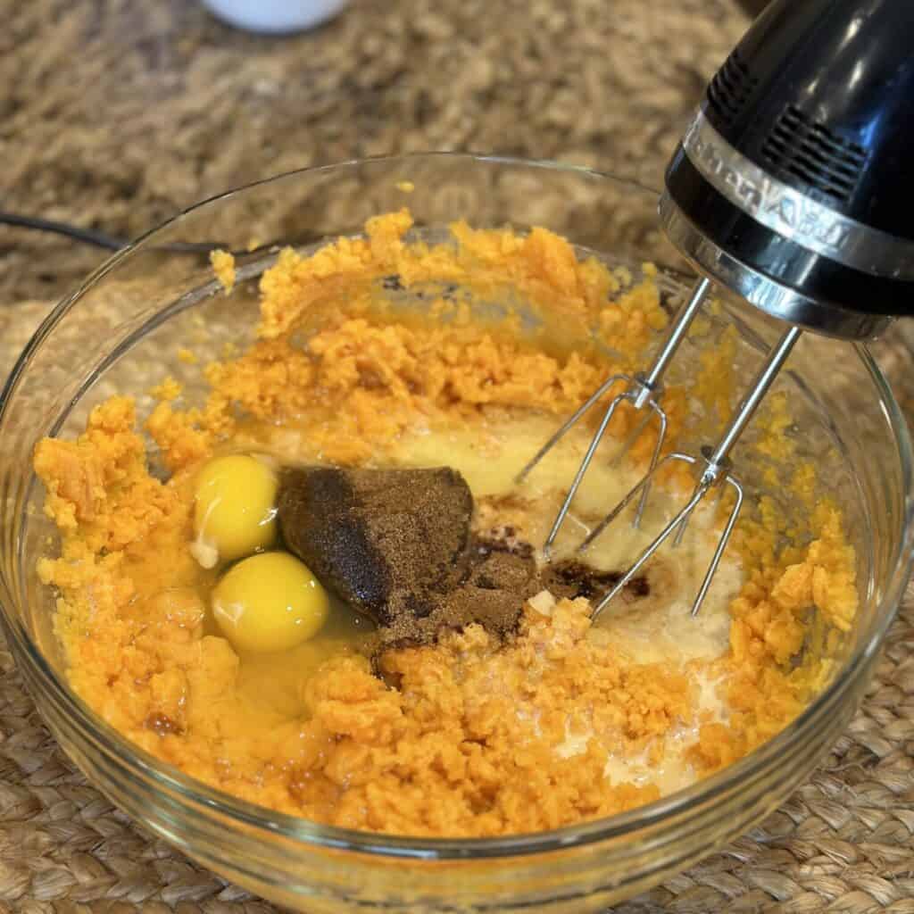 Whipping sweet potato casserole mixture in a bowl.