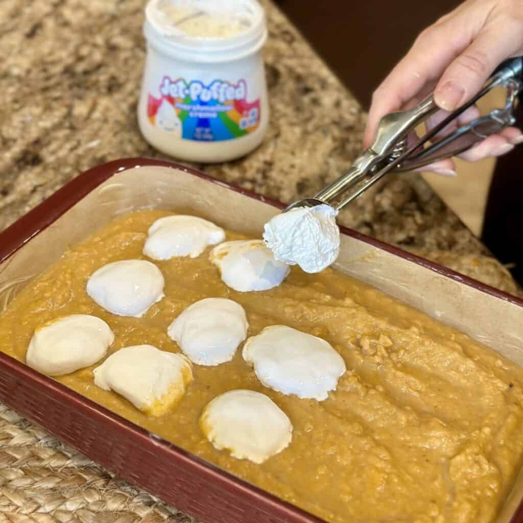 Adding marshmallow cream to sweet potatoes.