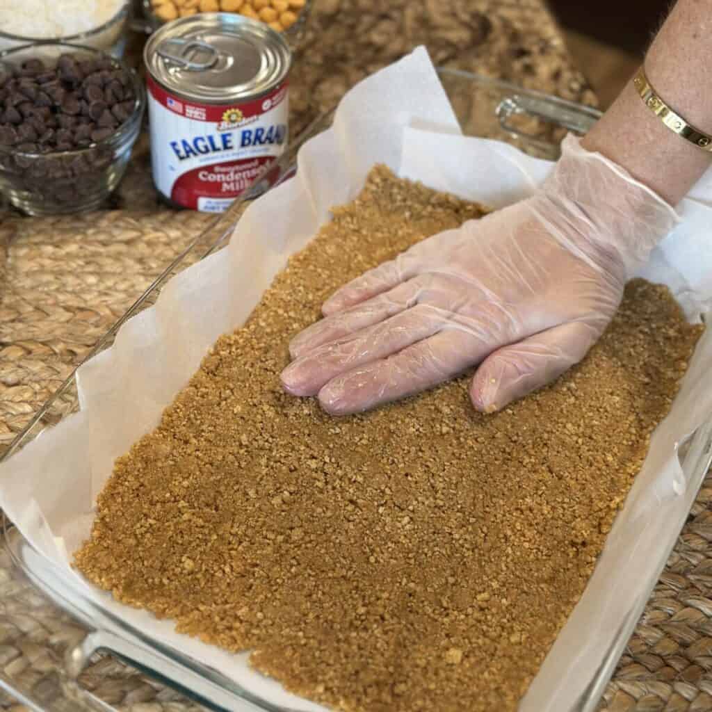 Pressing a graham cracker crust in a pan.