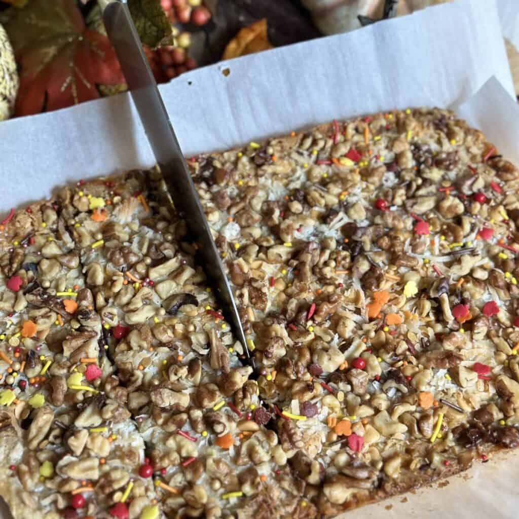 Cutting 7 layer magic cookie bars.