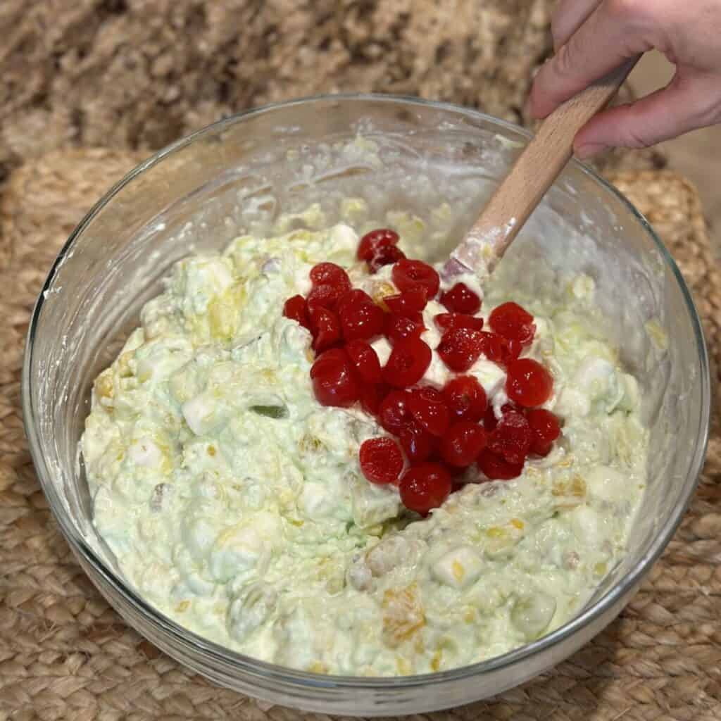 Folding cherries into pistachio ambrosia salad.