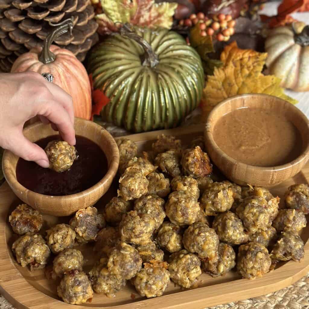 Dipping a sausage stuffing ball in cranberry sauce.