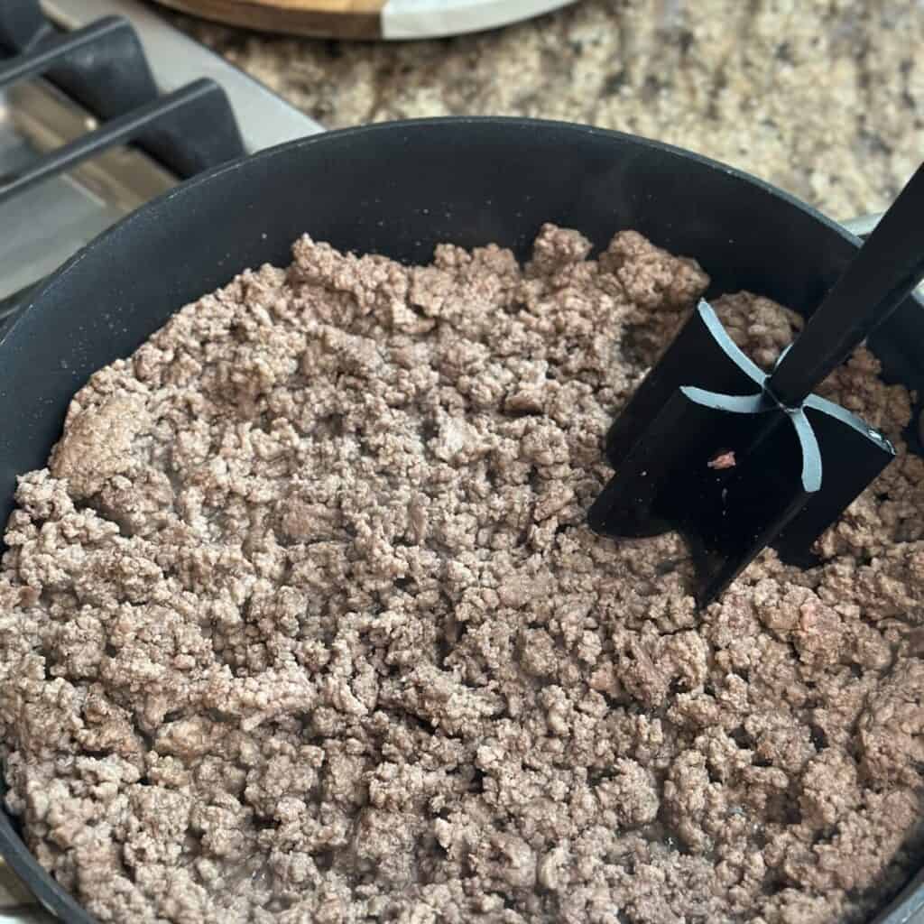 Browning ground beef in a skillet.