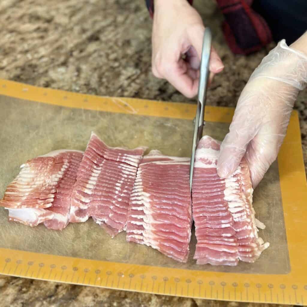 Cutting bacon in small pieces.