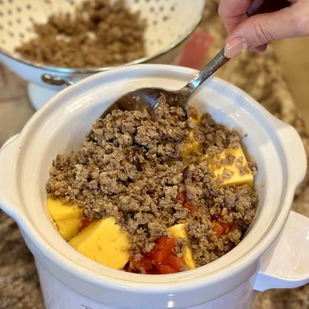 The ingredients to make cheese and sausage dip in a crockpot.