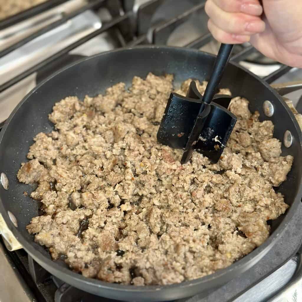 Browning sausage in a skillet.