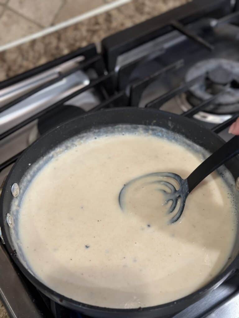 Stirring gravy in a pan.