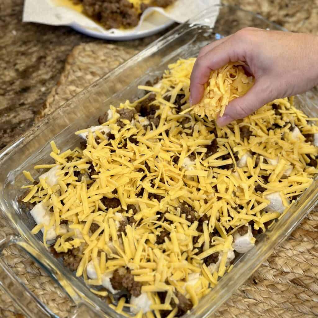 Assembling biscuits and gravy casserole in a baking dish.