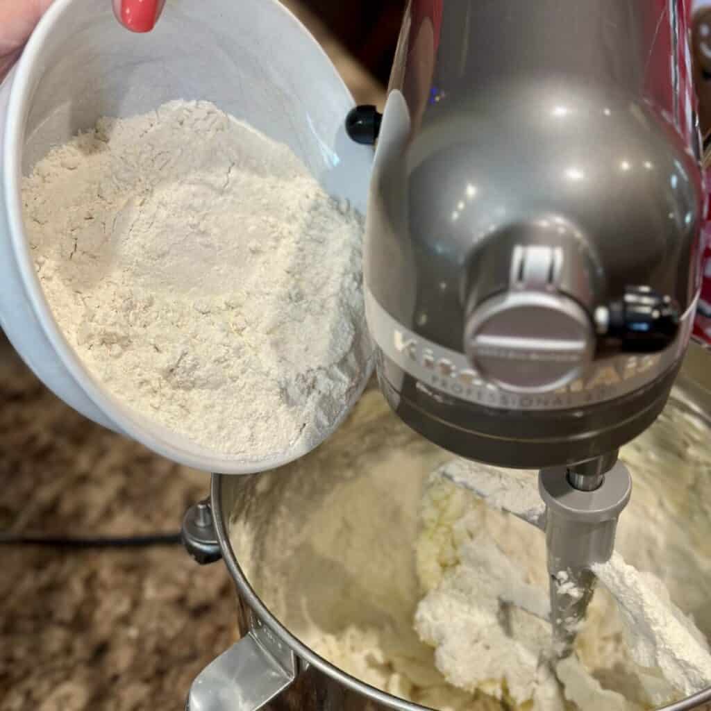 Adding flour to a cookie dough in a mixer.