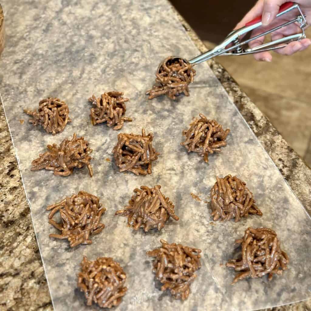 Scooping out haystack cookies on wax paper.