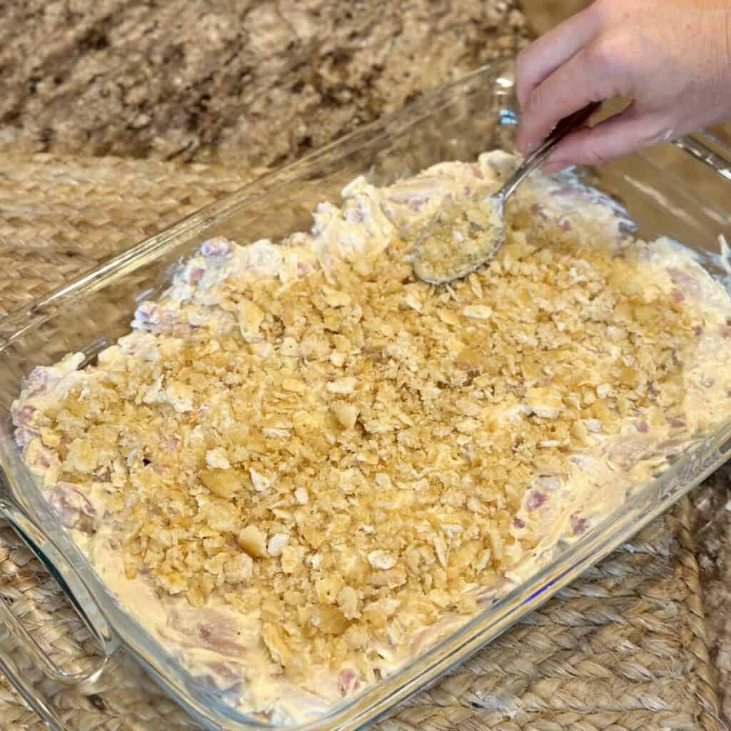 Adding a cracker topping to a chicken cordon bleu casserole.