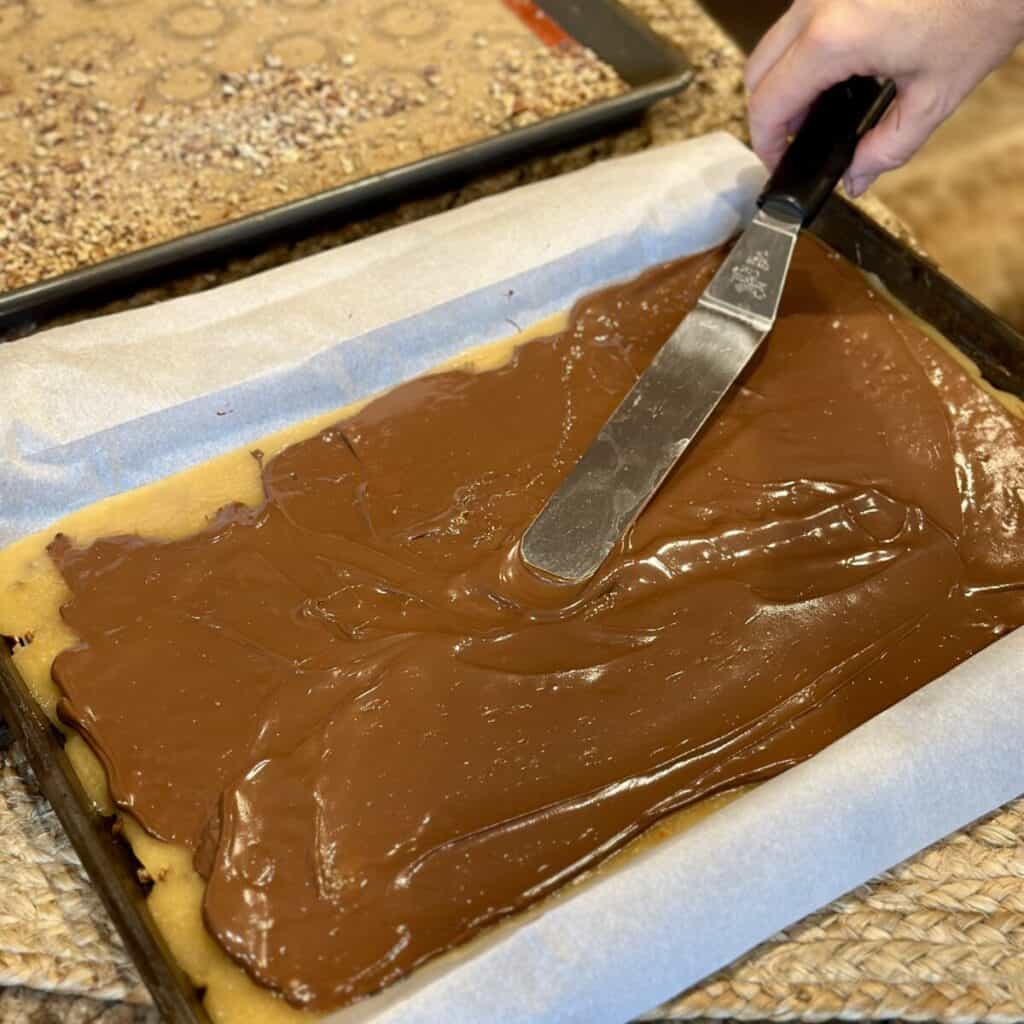 Spreading chocolate on butter toffee.