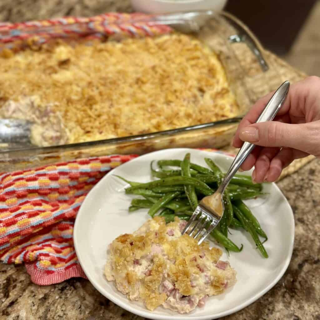 A plate of chicken cordon bleu casserole and green beans.