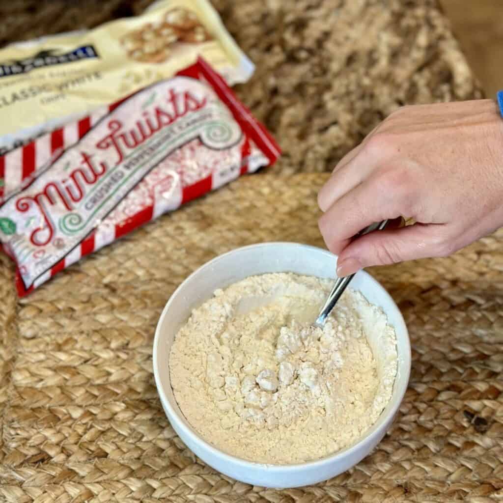 Mixing dry ingredients in a bowl for cookies.