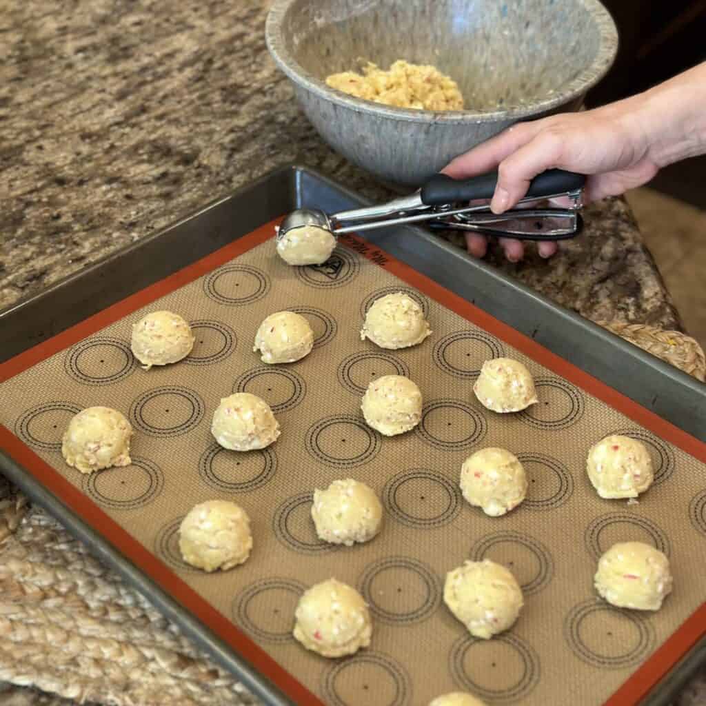 Scooping cookie dough on a pan.