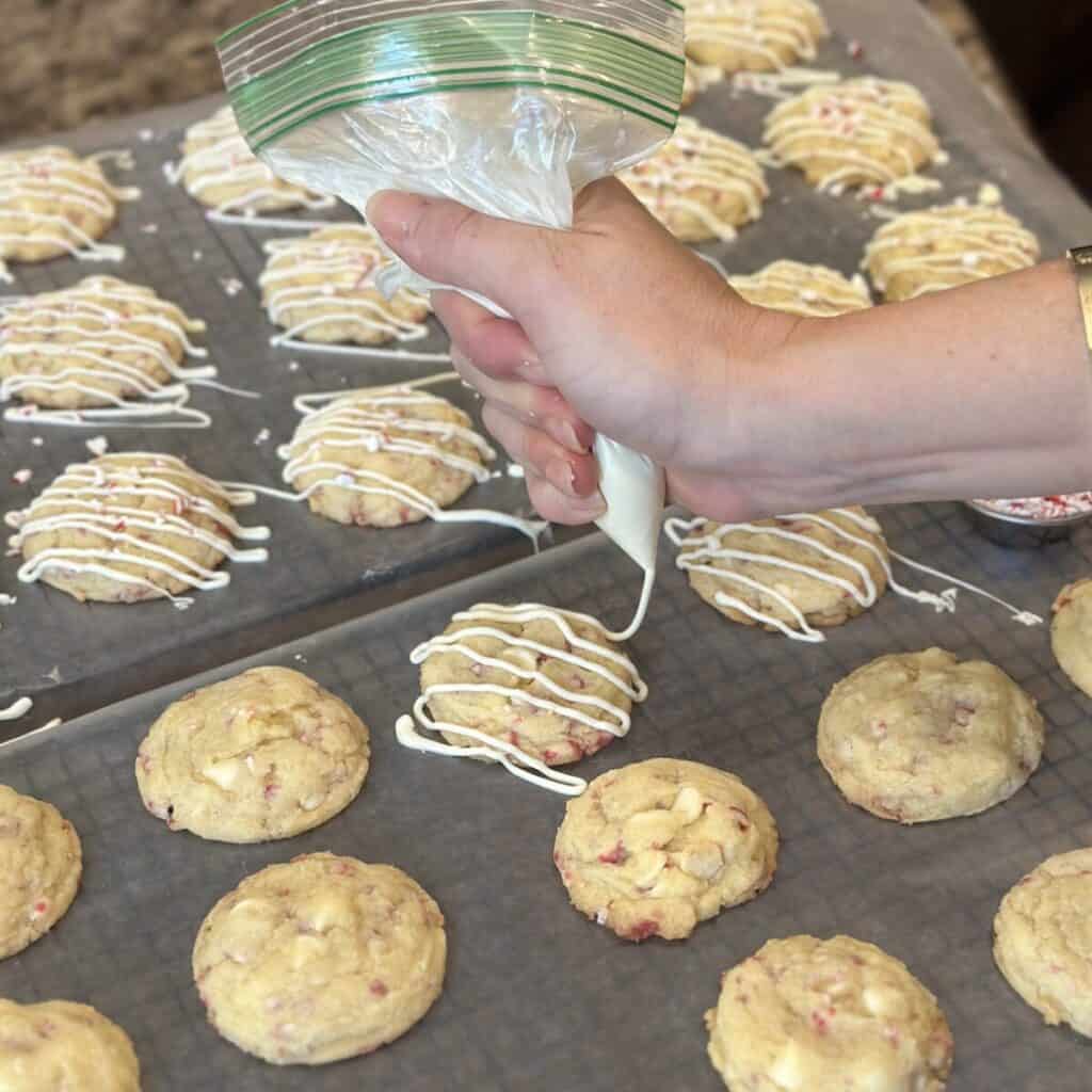 Drizzling white chocolate on cookies.