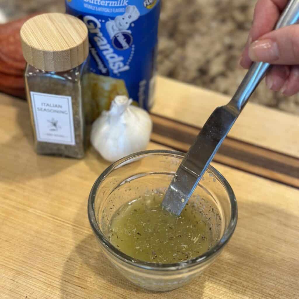 Whisking together garlic bread.