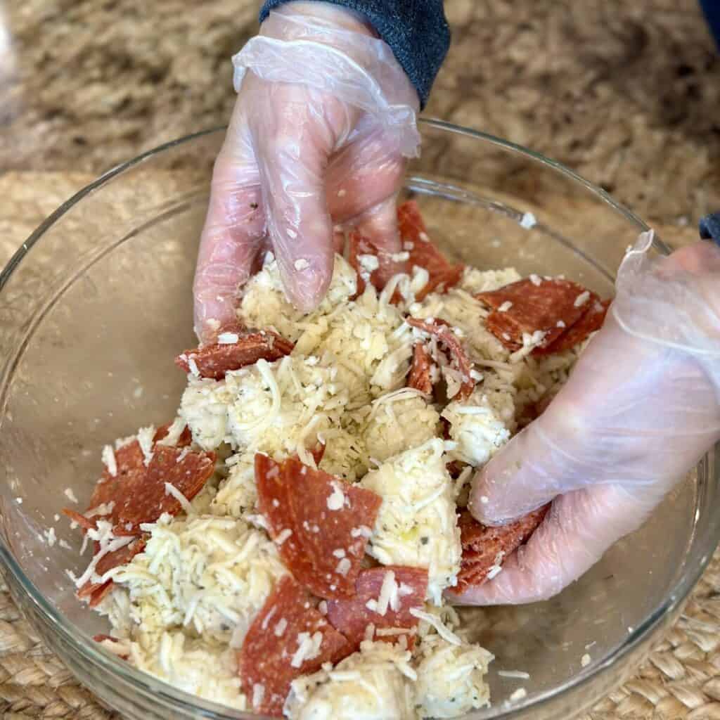 Mixing together the ingredients for pizza monkey bread.