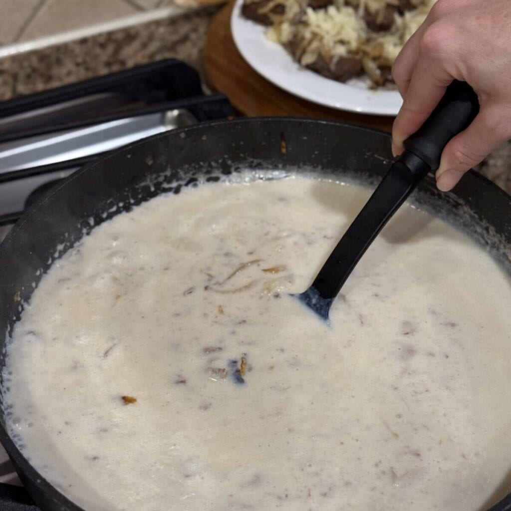 Stirring gravy in a skillet.