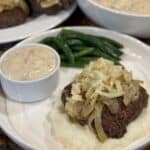 Hamburger steak with onion gravy on a plate.