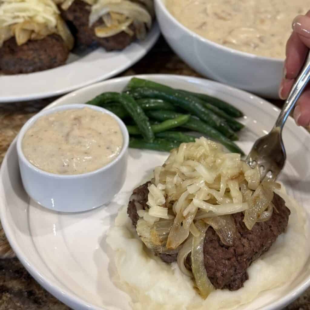 Hamburger steak with onion gravy on a plate.