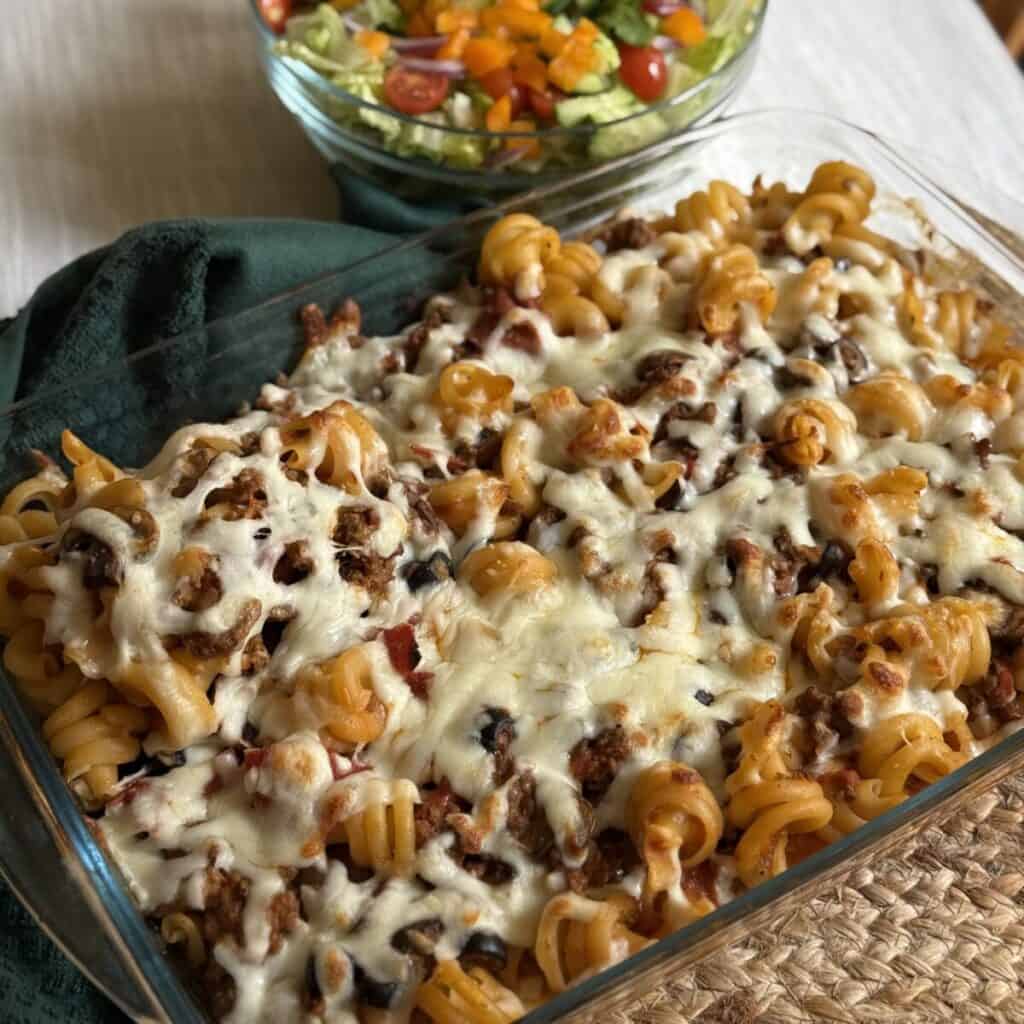 A baked pizza pasta recipe in a pan.