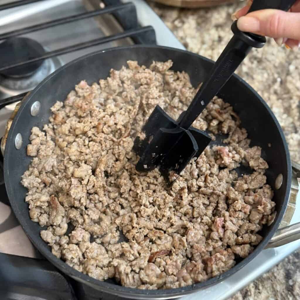 Browning italian sausage in a skillet.