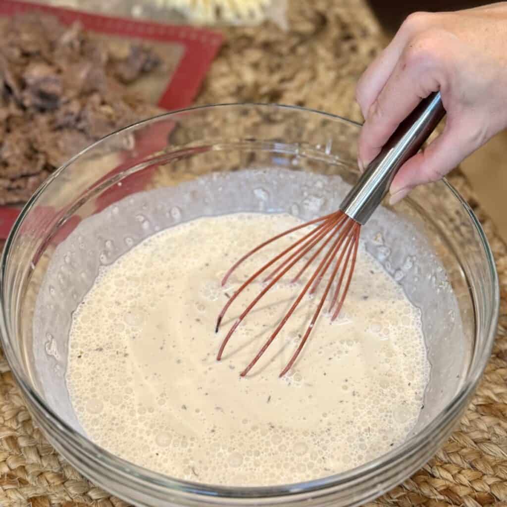 Mixing sour cream, milk and beef broth in a bowl.