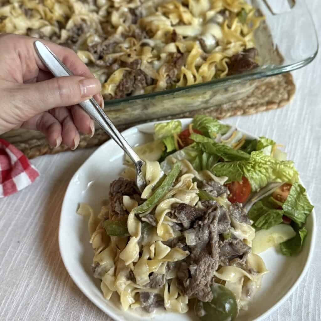 Philly cheesesteak casserole and salad on a plate.