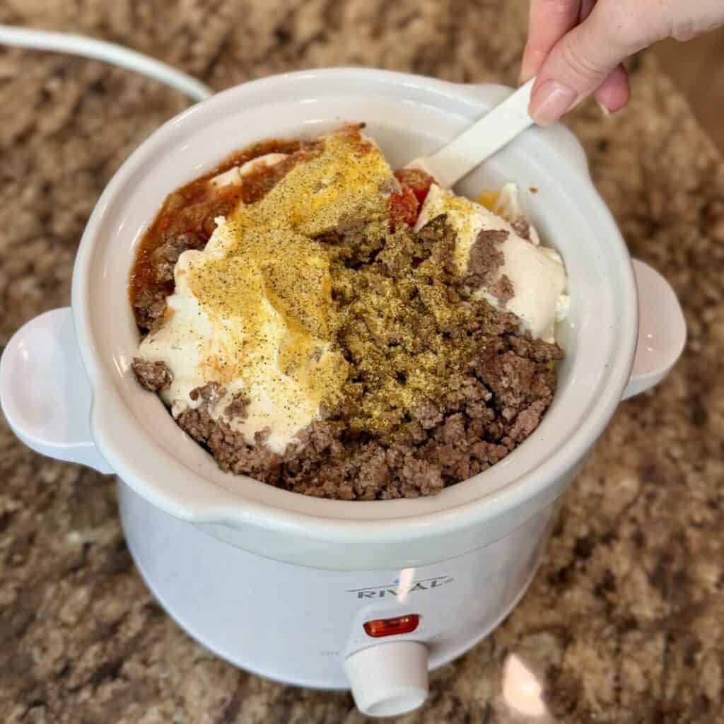 Stirring the ingredients for slow cooker taco dip.