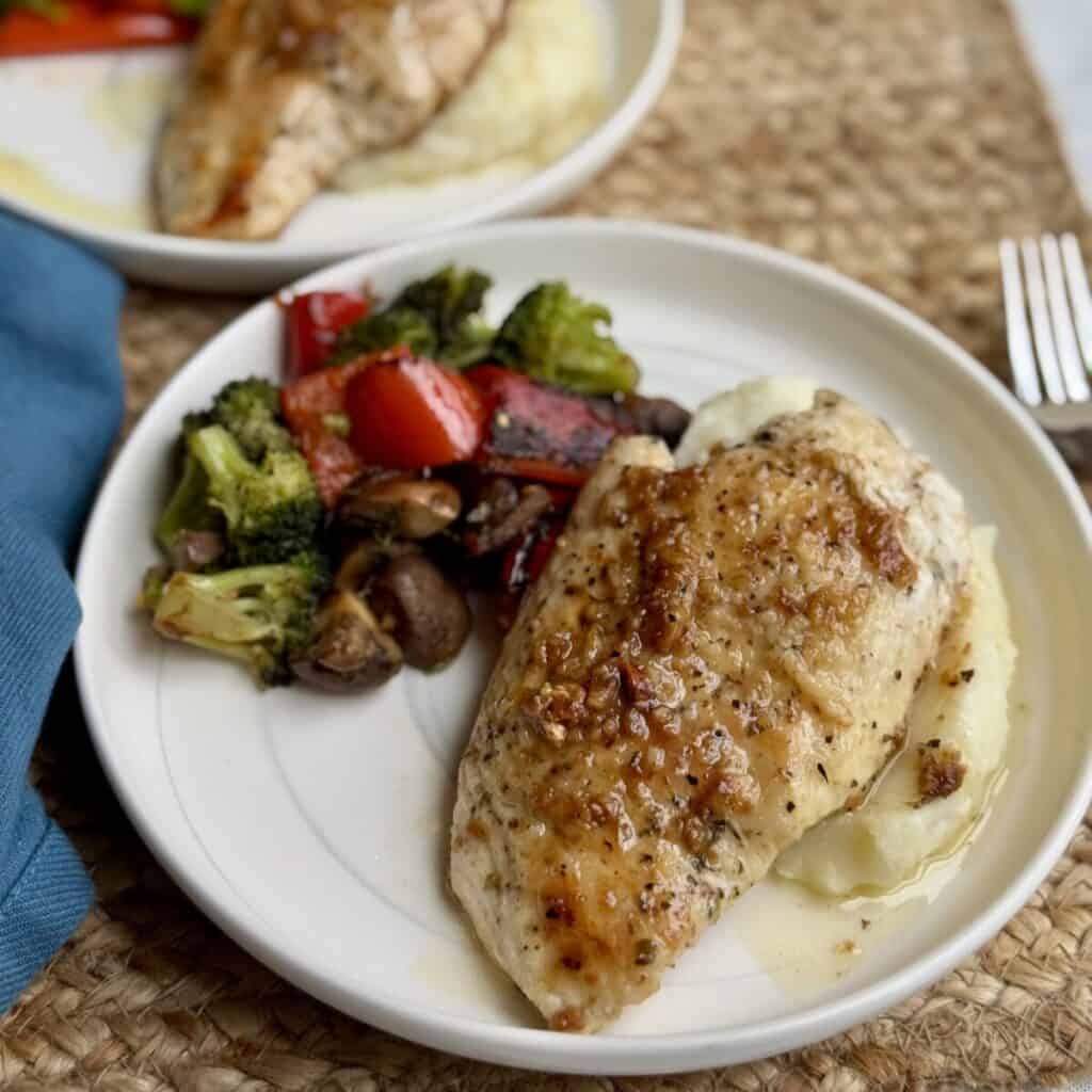 Garlic butter chicken on a plate and vegetables.